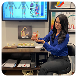 Chiropractor Santa Clarita CA Carolyn Griffin Holding Spine Diagram